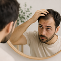 Paciente observando caída temporal del cabello tras un injerto capilar durante la fase de shock loss